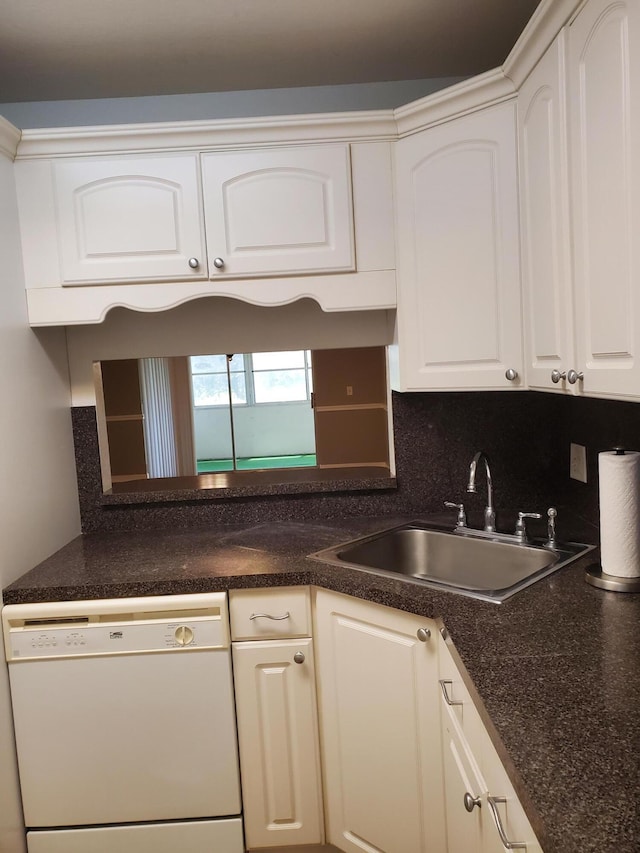 kitchen featuring a sink, dark countertops, white cabinetry, white dishwasher, and decorative backsplash