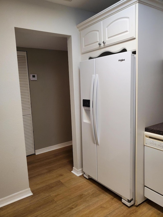 kitchen with baseboards, white appliances, white cabinets, and light wood finished floors