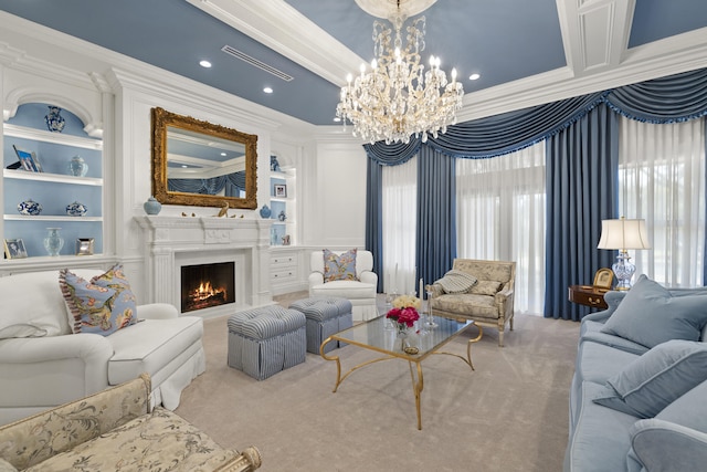 living area featuring built in features, a lit fireplace, ornamental molding, carpet flooring, and an inviting chandelier