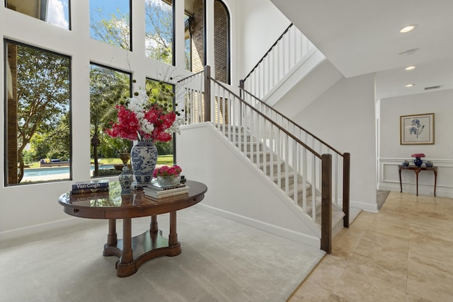 stairs with visible vents, a high ceiling, recessed lighting, and baseboards