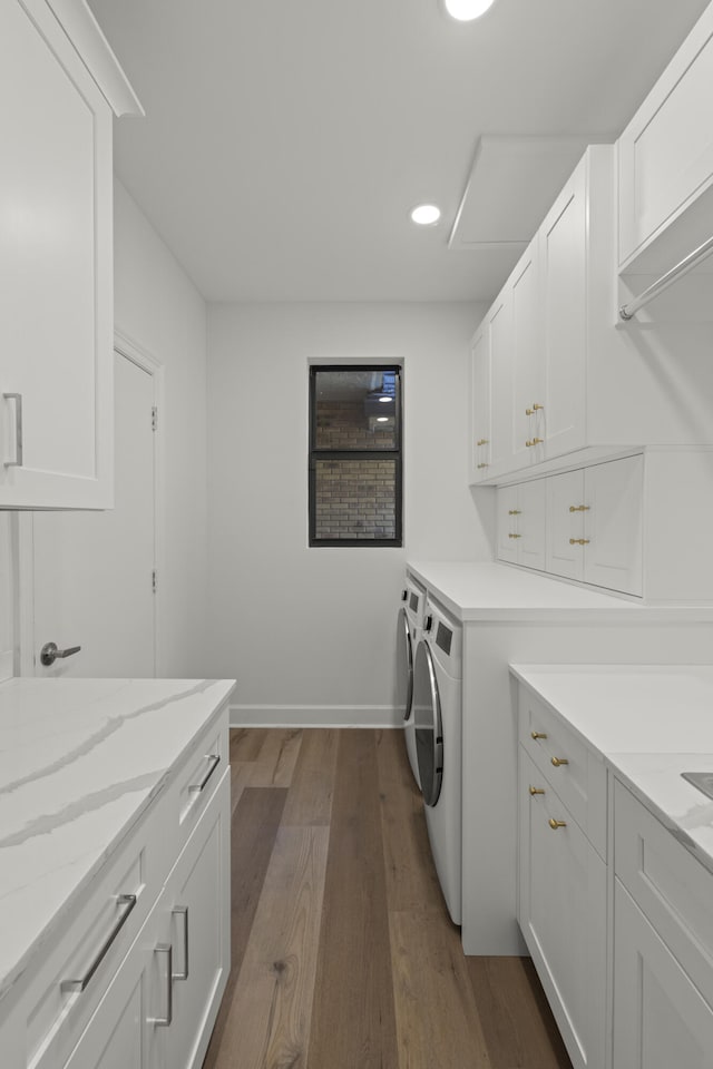 washroom featuring dark wood-type flooring, baseboards, recessed lighting, washer and dryer, and cabinet space