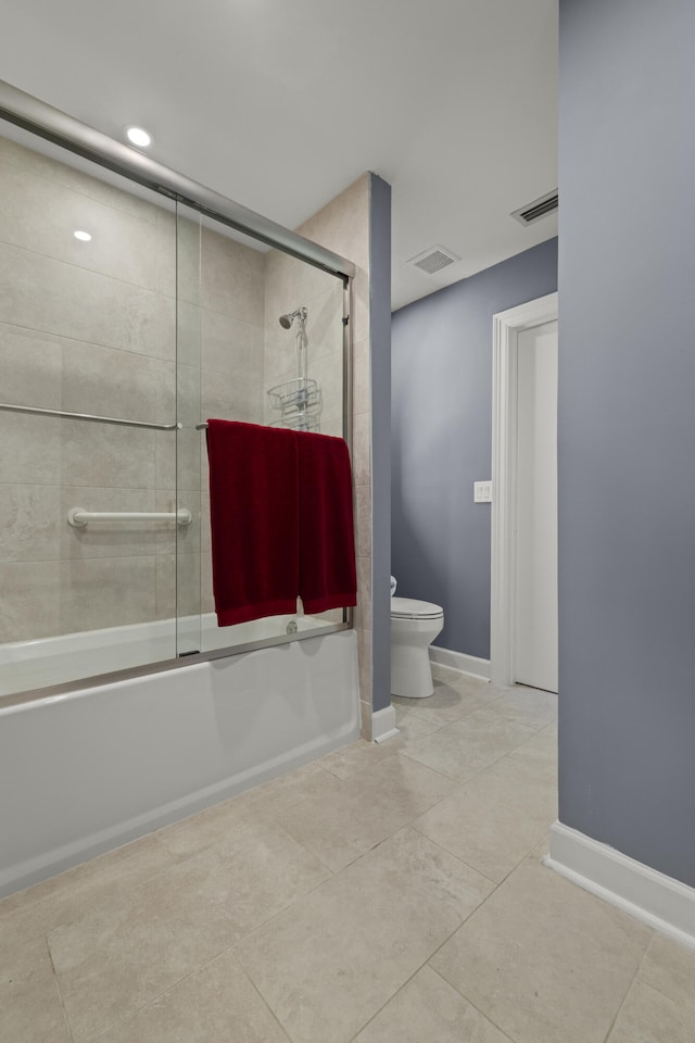 bathroom featuring toilet, baseboards, visible vents, and bath / shower combo with glass door