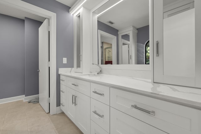 bathroom featuring tile patterned floors, visible vents, baseboards, and vanity