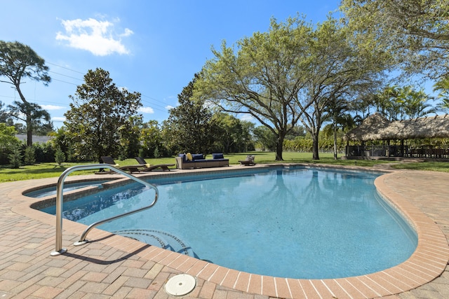 view of pool with a lawn, a pool with connected hot tub, and a patio