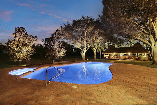 view of pool with a patio area and a pool with connected hot tub