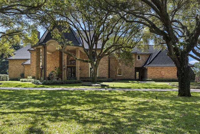 view of front of property featuring brick siding and a front lawn