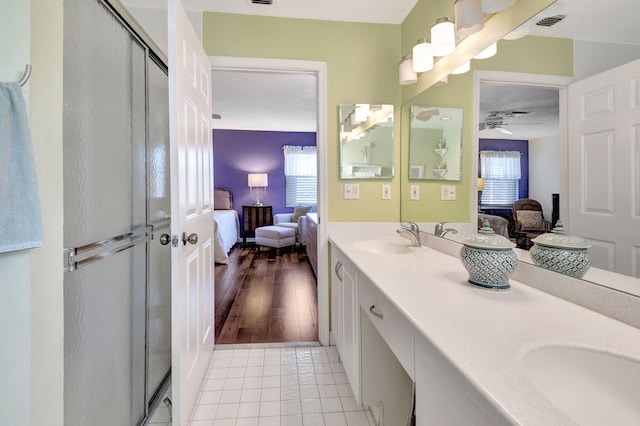 bathroom featuring tile patterned flooring, vanity, a shower with door, and ceiling fan