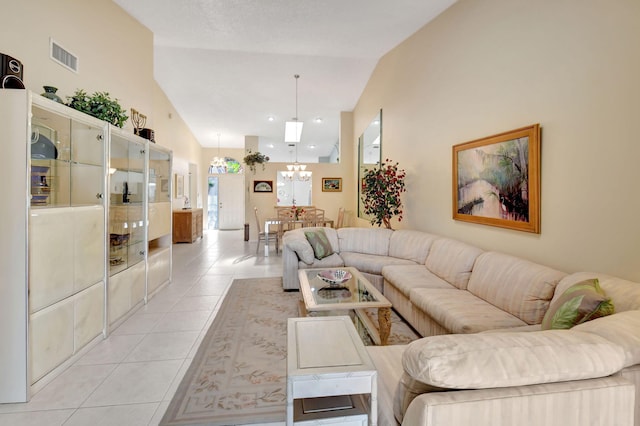 living room featuring vaulted ceiling, light tile patterned floors, and an inviting chandelier