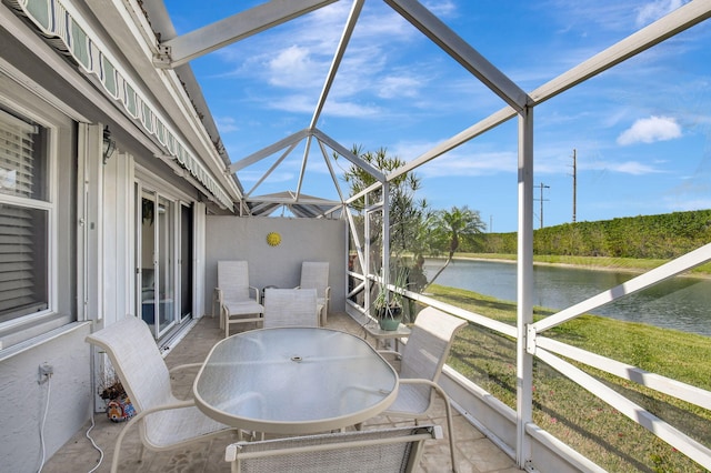 sunroom featuring a water view