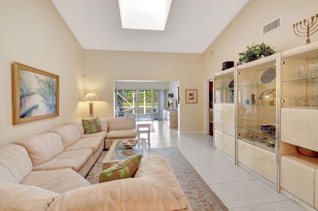 tiled living room featuring a skylight and high vaulted ceiling