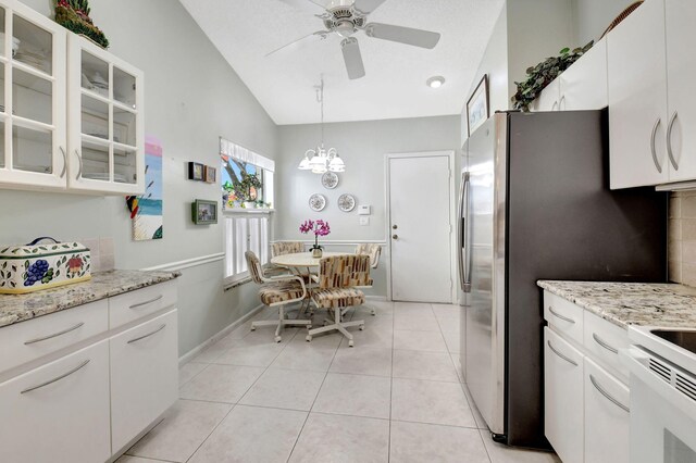 tiled living room featuring high vaulted ceiling and a skylight