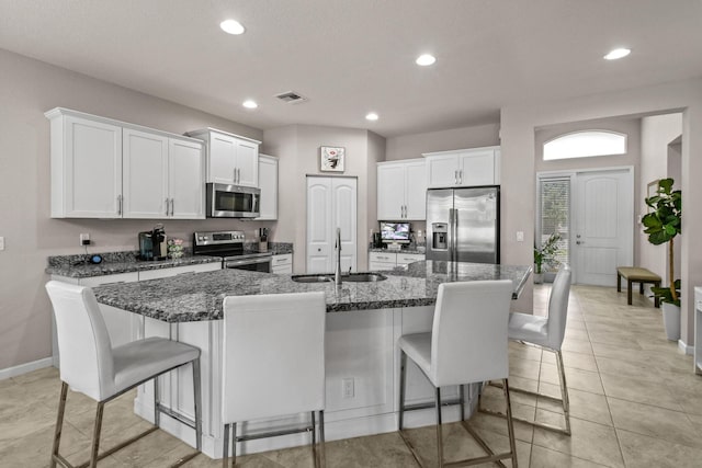 kitchen featuring an island with sink, stainless steel appliances, a kitchen breakfast bar, and sink