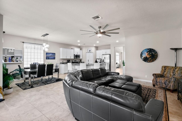 tiled living room featuring ceiling fan and a textured ceiling