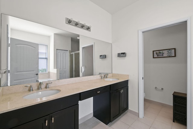 bathroom with tile patterned flooring, vanity, a shower with door, and toilet