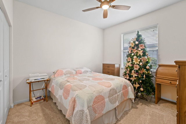 carpeted bedroom with ceiling fan and a closet