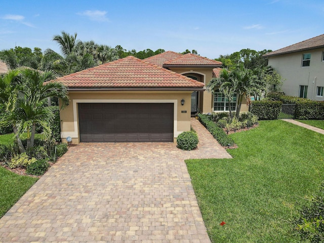 mediterranean / spanish house featuring a garage and a front lawn