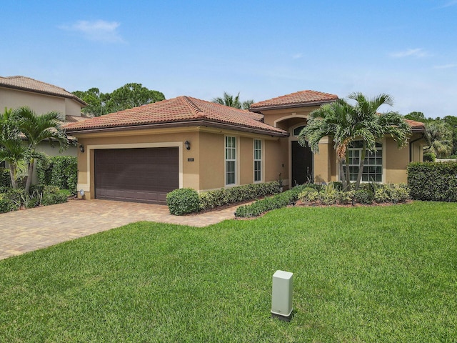 mediterranean / spanish-style house with a garage and a front lawn