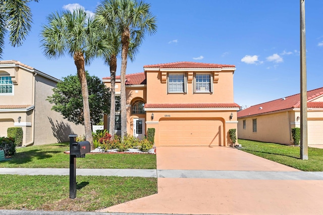 mediterranean / spanish-style home with driveway, a tile roof, a front yard, and stucco siding