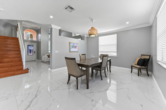 dining space with crown molding and a wealth of natural light