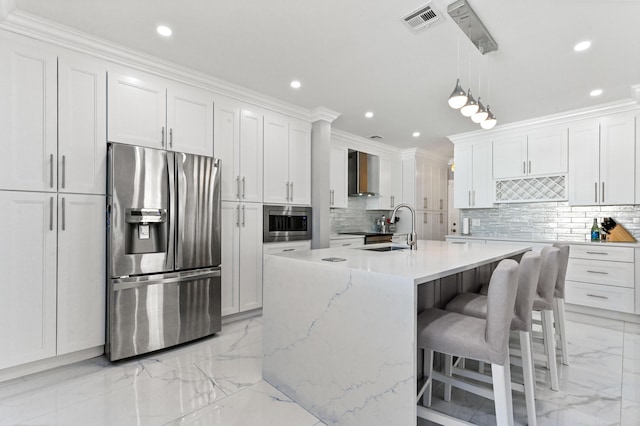 kitchen featuring sink, a center island with sink, wall chimney range hood, stainless steel appliances, and white cabinets