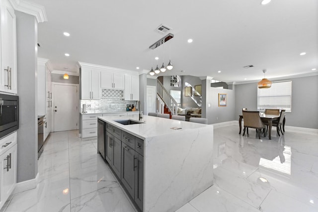 kitchen featuring a sink, visible vents, white cabinetry, a large island, and pendant lighting