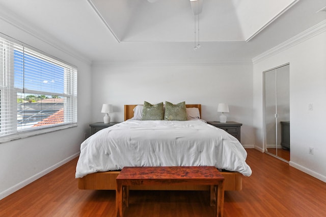 bedroom with crown molding, wood finished floors, and baseboards