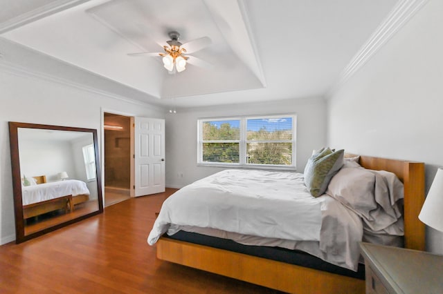 bedroom featuring baseboards, ceiling fan, ornamental molding, dark wood-type flooring, and a tray ceiling