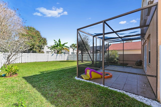 view of yard with glass enclosure, a fenced backyard, and a patio