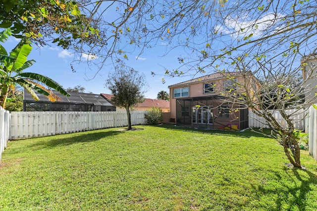 view of yard featuring a fenced backyard and a sunroom