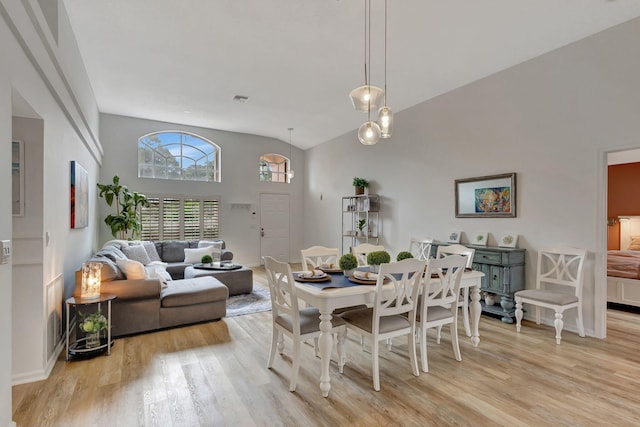 dining space featuring vaulted ceiling and light hardwood / wood-style floors