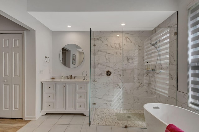 bathroom featuring tile patterned flooring, vanity, and shower with separate bathtub