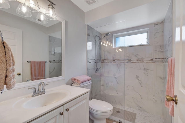 bathroom featuring a tile shower, vanity, and toilet