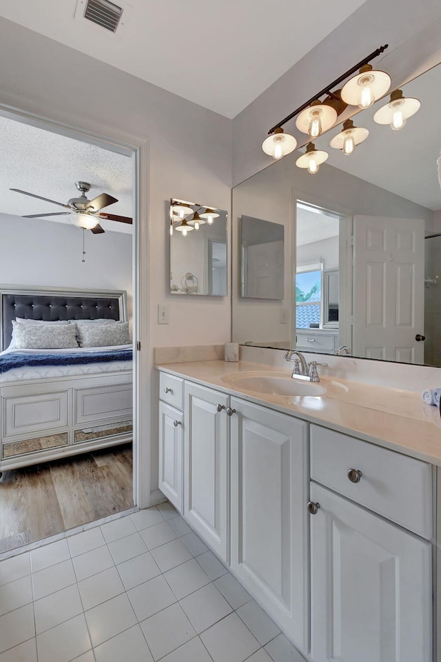 bathroom with tile patterned flooring, vanity, a textured ceiling, and ceiling fan