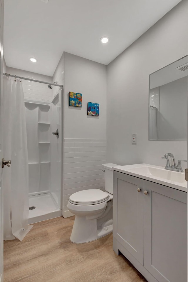 bathroom with wood-type flooring, a shower with shower curtain, and vanity