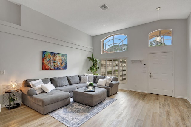 living room featuring light hardwood / wood-style floors and a high ceiling