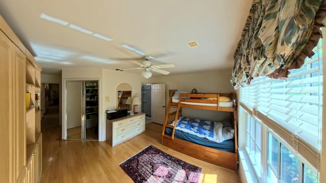 bedroom with light hardwood / wood-style floors, a closet, and ceiling fan