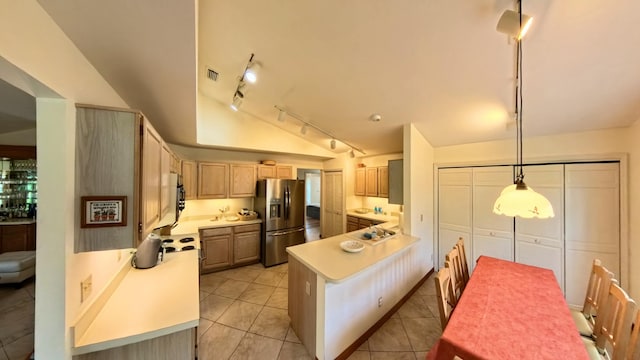 kitchen with light brown cabinetry, stainless steel fridge, hanging light fixtures, light tile patterned floors, and track lighting