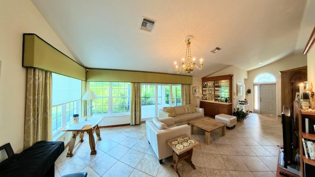 tiled living room featuring an inviting chandelier, plenty of natural light, and vaulted ceiling