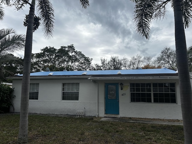 single story home with a front lawn