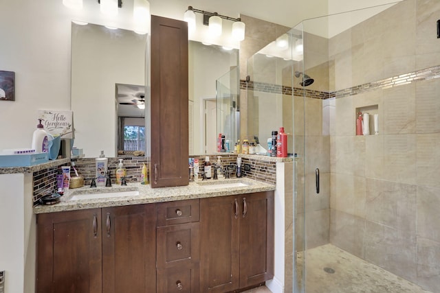 bathroom featuring tasteful backsplash, vanity, an enclosed shower, and ceiling fan