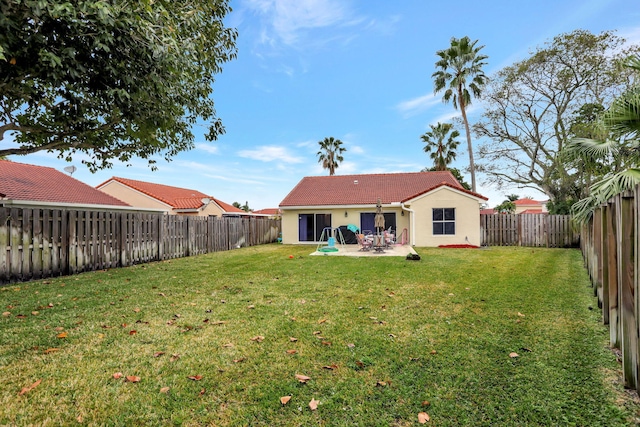 rear view of house with a yard and a patio area