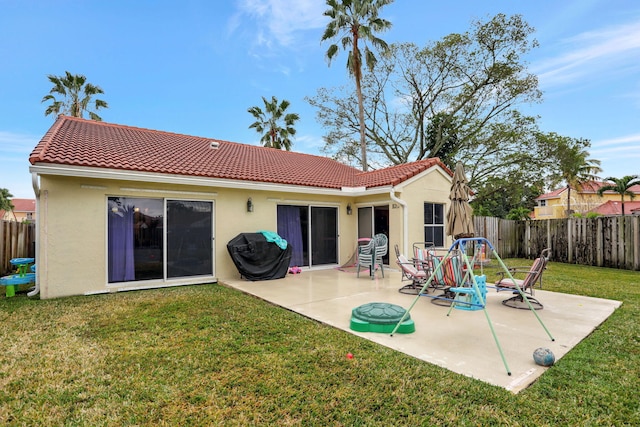 back of property with a patio area and a lawn