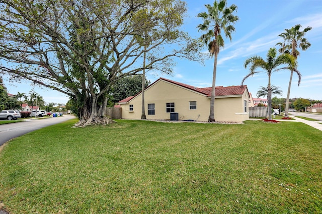 view of side of home with cooling unit and a yard