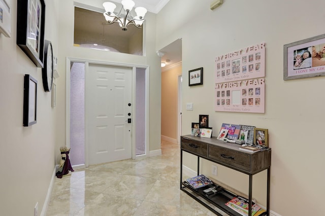 foyer featuring an inviting chandelier, a towering ceiling, and ornamental molding