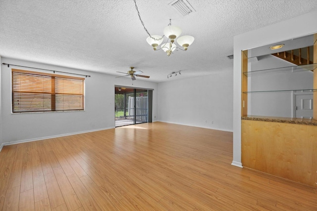 unfurnished room with ceiling fan with notable chandelier, light hardwood / wood-style flooring, and a textured ceiling