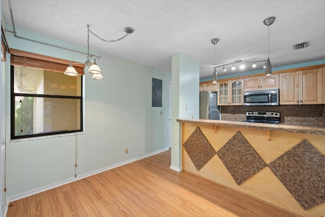 kitchen with light hardwood / wood-style flooring, appliances with stainless steel finishes, tasteful backsplash, a textured ceiling, and light brown cabinetry