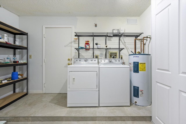 laundry room with water heater, a textured ceiling, and independent washer and dryer