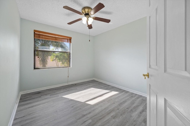 spare room featuring a textured ceiling, light hardwood / wood-style flooring, and ceiling fan