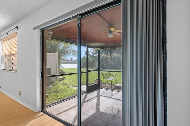 entryway with ceiling fan, wood-type flooring, and a textured ceiling