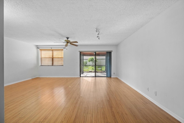 spare room with ceiling fan, light hardwood / wood-style floors, and a textured ceiling